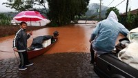 Warga mengungsi ke lokasi yang lebih tinggi menggunakan perahu.