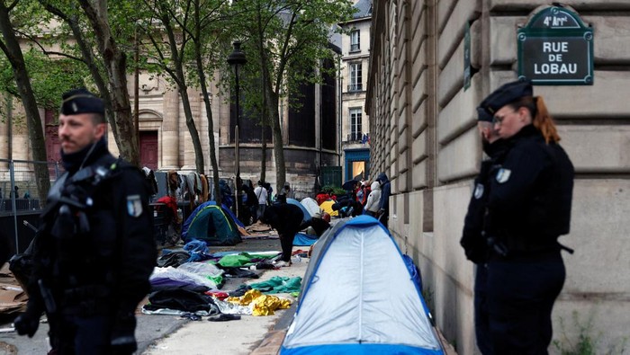 French Gendarmes walk past migrant tents during the evacuation of the camp on Place Saint-Gervais near Paris City Hall, France, April 30, 2024. REUTERS/Abdul Saboor