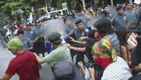 Polisi berusaha menghalangi para aktivis saat mereka mencoba berjalan menuju Kedutaan Besar AS saat protes memperingati Hari Buruh Internasional di Manila, Filipina. Ratusan pekerja Filipina dari berbagai kelompok buruh turun ke jalan untuk memperingati Hari Buruh dan menuntut kenaikan upah dan keamanan kerja di tengah melonjaknya harga pangan dan minyak. AP/Basilio Sepe