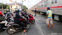 Petugas berjaga saat kereta melintas, karena palang perlintasan tidak dihiraukan.  