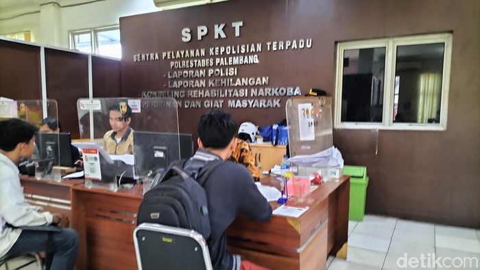 RF (kemeja hitam) saat sedang malaporkan kejadian pemerasan yang dialami kepada petugas Polrestabes Palembang.