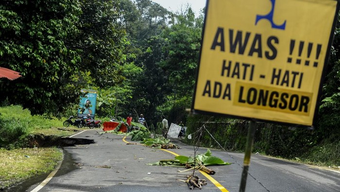 Warga melihat kondisi jalan yang amblas di Cipanas, Lebak, Banten, Kamis (2/5/2024). Ruas jalan antarprovinsi Banten dan Jawa Barat tersebut amblas pada Kamis (2/5/2024) dini hari, dan menyebabkan kendaraan berat tidak bisa melintas jalan tersebut untuk sementara waktu. ANTARA FOTO/Muhammad Bagus Khoirunas/foc.