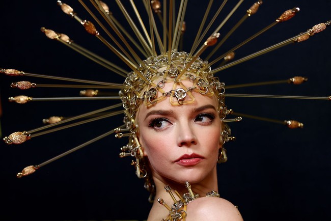 Busananya dilengkapi hiasan kepala berbentuk seperti topi baja berwarna emas. Foto: Getty Images/Brendon Thorne