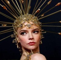 Busananya dilengkapi hiasan kepala berbentuk seperti topi baja berwarna emas. Foto: Getty Images/Brendon Thorne