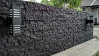 Pagar dinding yang bertekstur seperti ini dibuat dengan menggabungkan batu alam dan campuran beton. Tak hanya asri, desain ini memberikan kesan elegan dan berkarakter pada rumah. Foto: Weiss Stone/Pinterest