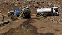Tampak mobil-mobil tanker mengisi air ke dalam sumur kering.  