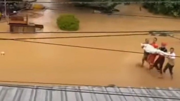 Warga di Kabupaten Luwu, Sulawesi Selatan (Sulsel) menggotong jenazah menerobos banjir.