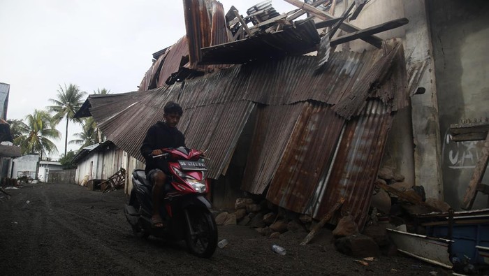 Ribuan Rumah Rusak Terdampak Erupsi Gunung Ruang Warga melintas di depan rumah yang rusak akibat erupsi Gunung Ruang di Tagulandang, Kabupaten Kepulauan Sitaro, Sulawesi Utara, Kamis (2/5/2024). BPBD mencatat sebanyak 3.614 unit rumah mengalami kerusakan di Tagulandang yang tersebar di dua kelurahan dan 13 kampung akibat erupsi Gunung Ruang. ANTARA FOTO/Andri Saputra/nym.