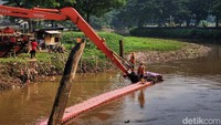 Endapan lumpur terlihat saat para pekerja mengeruk sampah sungai di Kali Pesanggrahan. Musim hujan yang membawa lumpur mendorong proses pendangkalan sungai berlangsung lebih cepat.  