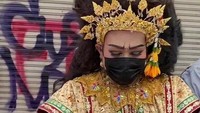 Tak kenal cuaca maupun gerah, penjual ayam goreng di Thailand tampil dengan penuh niat. Ia memilih mengenakan pakaian tradisional lengkap dengan perhiasan, sarung tangan, hingga rambut palsunya. Foto: TikTok/bangkokfoodie