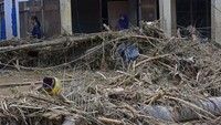 Warga mencari barang berharga yang masih bisa diselamatkan pascabanjir bandang.