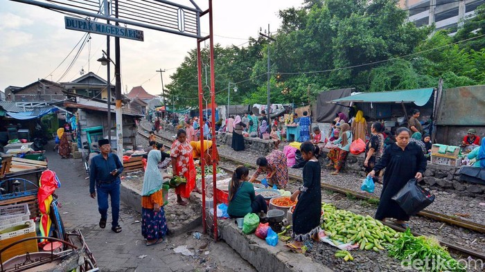 Surabaya- Sejumlah warga nekat melakukan aktivitas jual beli di perlintasan rel kereta api di Pasar Ekstrem Dupak Magersari, Surabaya, Minggu (5/5/2024). Setiap pagi sedikitnya tiga sampai empat kereta api yang melintas.