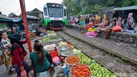 Para pedagang berhenti aktivitas saat kereta sedang melintas. Ada dua perlintas kereta api di Pasar Ekstrem Dupak Magersari.