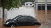 Hujan lebat telah mengubah permukiman warga menjadi sungai karena banjir. Mobil warga yang tak sempat diselamatkan pun akhirnya jadi korban. AP/Carlos Macedo