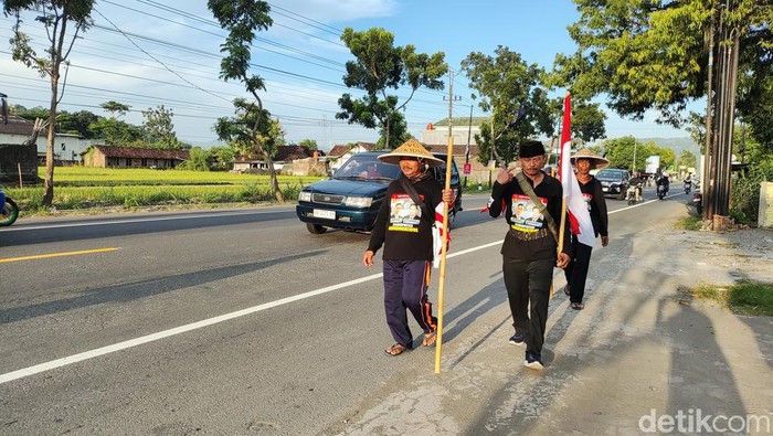 Tiga warga Padukuhan Banaran V, Playen, Gunungkidul, sampai di jalan Jogja-Wonosari di Piyungan, Bantul, Minggu (5/5/2024). Mereka menunaikan nazar jalan kaki menuju kediaman Prabowo Subianto di Kertanegara, Jakarta.
