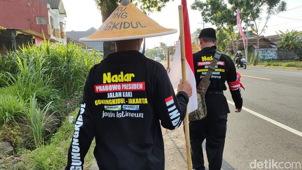 Tiga warga Padukuhan Banaran V, Playen, Gunungkidul, sampai di jalan Jogja-Wonosari di Piyungan, Bantul, Minggu (5/5/2024). Mereka menunaikan nazar jalan kaki menuju kediaman Prabowo Subianto di Kertanegara, Jakarta.
