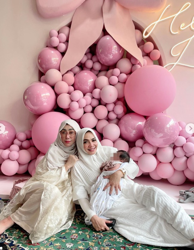 Kedua nenek Rafathar dan Rayyanza itu tampil kompak mengenakan busana berwarna putih. Mereka juga terlihat tak kalah menyayangi baby Lily seperti Nagita dan Raffi. Foto: Instagram/@rieta_amiliia