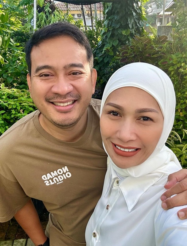 Seperti unggahan selanjutnya, Tata Janeeta berfoto selfie bersama suaminya, Raden Brotoseno. Tata terlhat mengenakan hijab putih yang dipadu dengan kemeja warna putih. Foto: Dok. Instagram @tatajaneetaofficial.