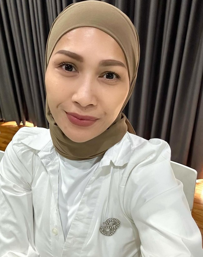 Tata Janeeta yang kini memiliki kesibukan baru merintis bisnis produk kosmetik @tjbytatajaneeta terlihat membentuk hijabnya rapi dengan mengikatnya ke belakang. Seperti di dalam foto ini, Tata tampil dengan hijab warna coklat muda. Foto: Dok. Instagram @tatajaneetaofficial.