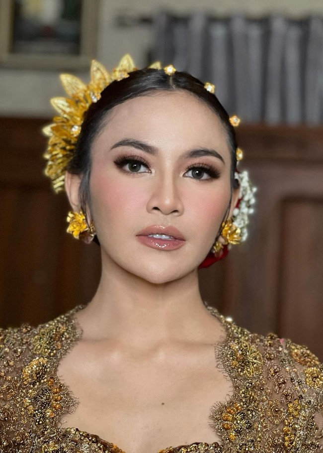 Warna oranye dengan gradasi copper dipulaskan pada bagian mata. Sementara pipi diberikan pulasan blush-on peach yang menambah semburat segar. Foto: Instagram/@ochiipramita