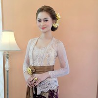 Nindy tampil anggun dalam balutan kebaya Bali berwarna krem dan kain songket berwarna ungu gelap dan coklat muda. Penampilannya itu kemudiann dilengkapi dengan ikat pinggang berwarna coklat. Dengan rambut tersanggul dan pulasan makeup natural glow, penampilan Nindy semakin terlihat ayu. Foto: Instagram/@nindypricilia