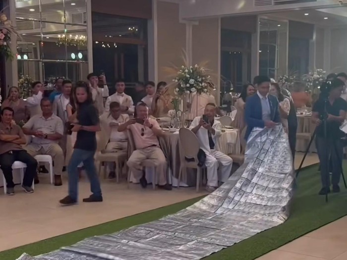 Pengantin pria ini memberikan karpet uang tunai untuk pengantin wanita di hari pernikahannya. Momen tersebut langsung viral di media sosial