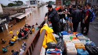 Orang-orang diselamatkan dari banjir yang melanda Canoas, di negara bagian Rio Grande do Sul, Brasil, Minggu (5/5). Perahu hilir mudik mengevakuasi warga terdampak banjir.