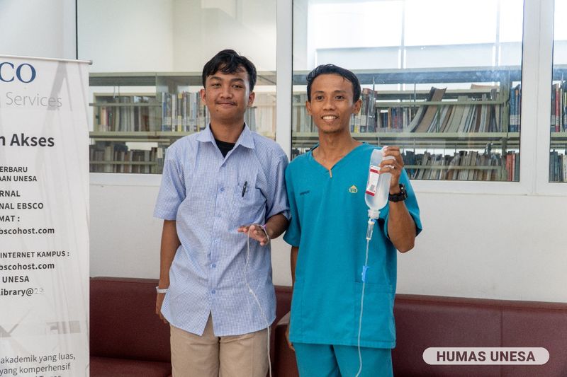 Peserta UTBK di Unesa yang datang dengan tangan diinfus dan ditemani perawat