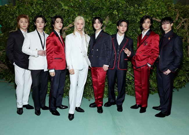 Leader grup KPop Stray Kids, Bangchan memakai three-piece wool suit berwarna navy dengan outline merah dan bros bunga sebagai aksesori. Sedangkan Felix tampil memakai silk suit putih dengan sulaman bunga yang selaras dengan dress code MET Gala 2024, The Garden of Time. Foto: Getty Images