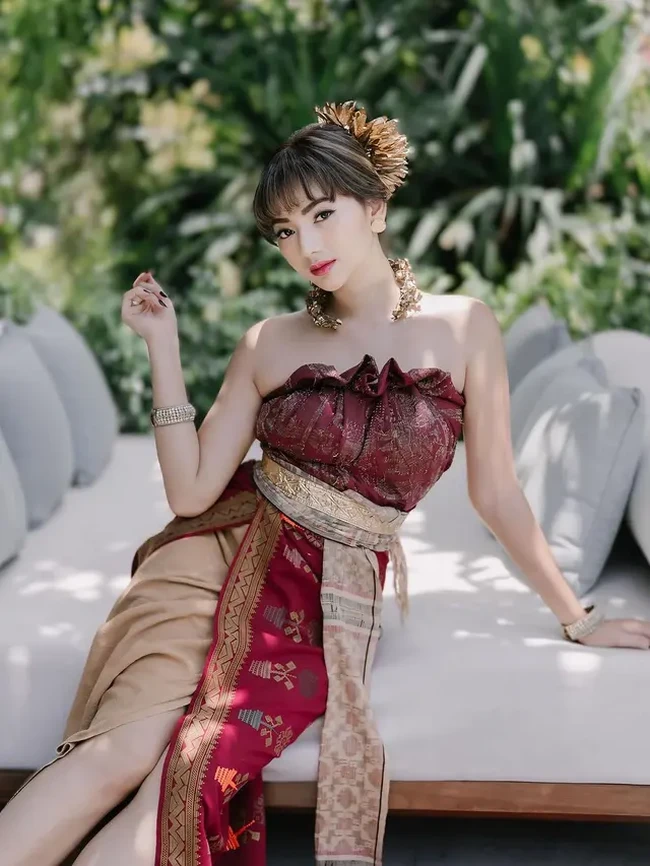 Bak putri bangsawan, gaya Glenca Chysara mengenakan busana adat Bali berwarna merah marun dan coklat bikin terpana. Glenca memilih busana adat Bali berbentuk sepertii tube dress. Penampilannya juga dilengkapi dengan beragam aksesori seperti gelang, kalung, anting, dan hiasan kepala. Foto: Instagram