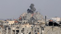 Asap mengepul dari gedung yanghancur akibat serangan udara Israel di Rafah di selatan Jalur Gaza, Senin (6/5/2024).