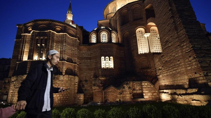 A Muslim cleric walks along a former Byzantine church which formally opened as a mosque, in Istanbul, Turkey, Monday, May 6, 2024. Turkish President Recep Tayyip Erdogan formally opened a former Byzantine church in Istanbul as a mosque on Monday, four years after his government had designated it a Muslim house of prayer, despite criticism from neighboring Greece. (AP Photo/Emrah Gurel)