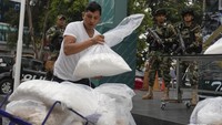 Seorang pekerja kota mengatur tas berisi kokain yang disita untuk presentasi media di markas narkotika polisi di Lima, Peru, Senin (6/5). Polisi mengatakan mereka menyita lebih dari satu ton kokain secara nasional pada bulan April di Lembah Apurimac, sebuah wilayah yang dikenal sebagai VRAEM.