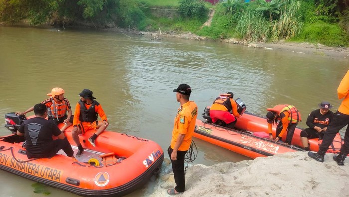 Petugas BPBD mencari pengukur kedalaman sungai Hengki Firmansyah yang tenggelam di Sungai Silau, Kisaran. (Istimewa)
