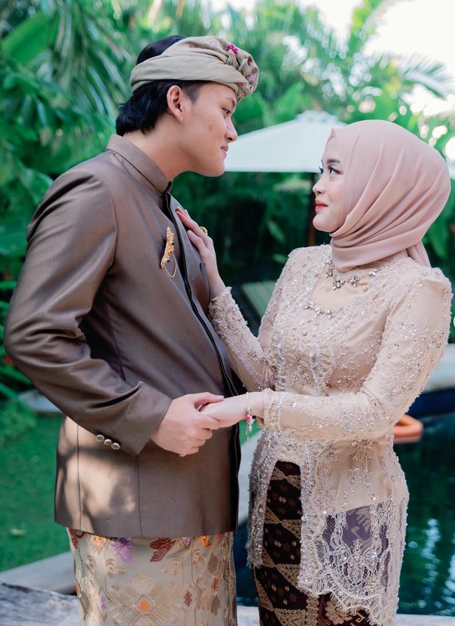 Putri Delina terlihat hadir dengan mengenakan kebaya Bali berwarna coklat yang merupakan seragam untuk anggota keluarga. Ia pun sempat berpose bersama sang kakak, Rizky Febian yang akan segera mengakhiri masa lajangnya. Foto: Instagram/@putridelinaa