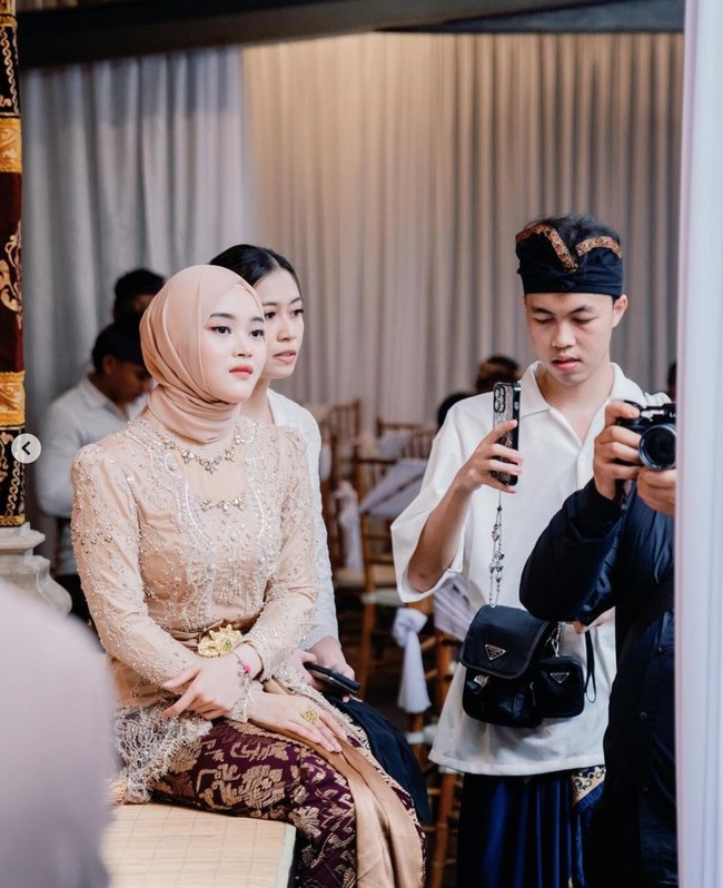 Dalam foto terlihat Putri Delina yang begitu serius melihat prosesi Mepamit calon kakak iparnya, Mahalini.  Foto: Instagram/@putridelinaa