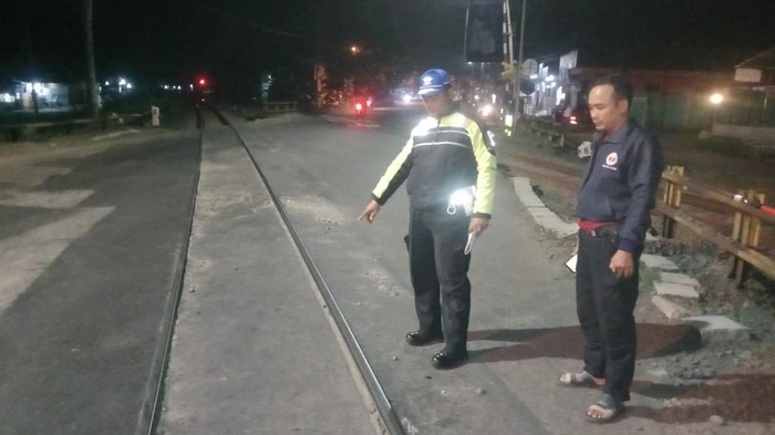 Petugas kepolisian menunjukkan lokasi pemotor yang tewas tertabrak kereta api karena menerobos palang pintu di perlintasan Sumpiuh, Kabupaten Banyumas, Senin (6/5/2024) malam.