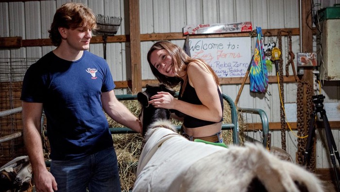 Emma Maiers sits with cows and goats during a cow cuddle session at Luz Farms near Monee, Illinois, U.S. April 15, 2024. REUTERS/Jim Vondruska