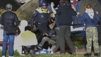 Polisi terlihat menendang pengunjuk rasa dan menghancurkan tenda setelah para mahasiswa menolak meninggalkan kampus. (AP Photo InterVision)  