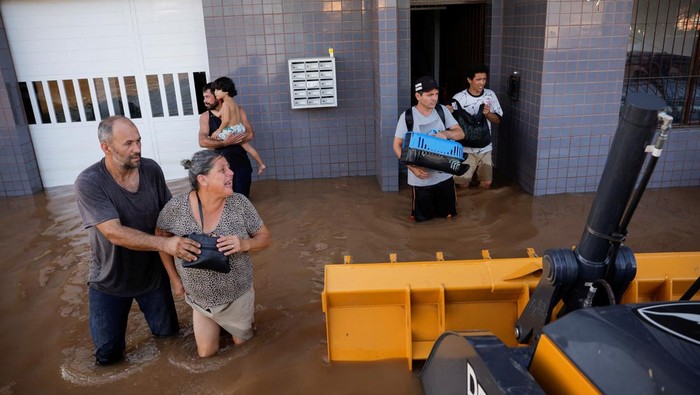 Evacuees ride in a loader after their homes were flooded at Eldorado do Sul, in Rio Grande do Sul Brazil May 7, 2024. REUTERS/Amanda Perobelli