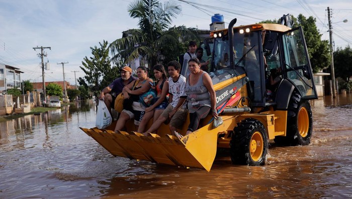 Alat Berat Dikerahkan untuk Evakuasi Korban Banjir di Brasil Evacuees ride in a loader after their homes were flooded at Eldorado do Sul, in Rio Grande do Sul Brazil May 7, 2024. REUTERS/Amanda Perobelli