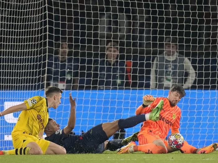 PSG's Kylian Mbappe, center, fails to score past Dortmund's goalkeeper Gregor Kobel, right, during the Champions League semifinal second leg soccer match between Paris Saint-Germain and Borussia Dortmund at the Parc des Princes stadium in Paris, France, Tuesday, May 7, 2024. (AP Photo/Christophe Ena)