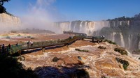 Orang-orang menjelajahi Air Terjun Iguazu, yang saat ini kapasitas airnya penuh akibat hujan di Brasil selatan, Selasa (7/5/2024). Menurut media lokal, curah hujan di air terjun tersebut tiga kali lipat dari biasanya, yaitu antara 1,5 hingga 3,6 juta liter air per detik.