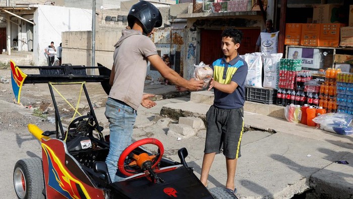 Suleiman Thaer, 19, delivers orders to help his father with his restaurant deliveries, using a car he made from scrap materials, in Mosul, Iraq, May 4, 2024. REUTERS/Khalid Al-Mousily