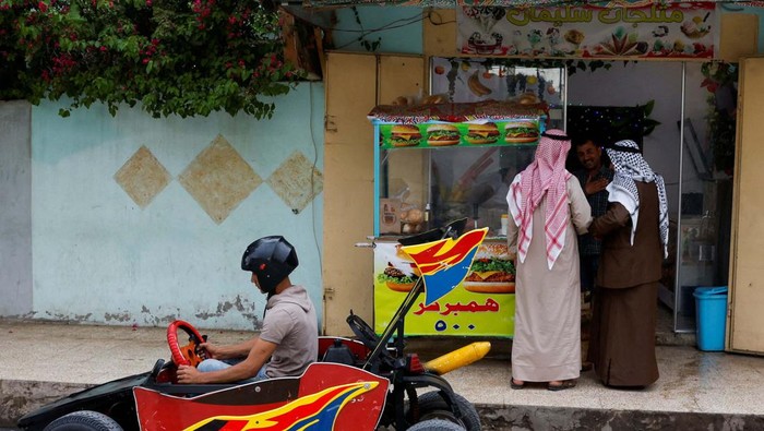 Kreatif! Pria Ini Bikin Mobil dari Barang Bekas untuk Antar Makanan Suleiman Thaer, 19, delivers orders to help his father with his restaurant deliveries, using a car he made from scrap materials, in Mosul, Iraq, May 4, 2024. REUTERS/Khalid Al-Mousily