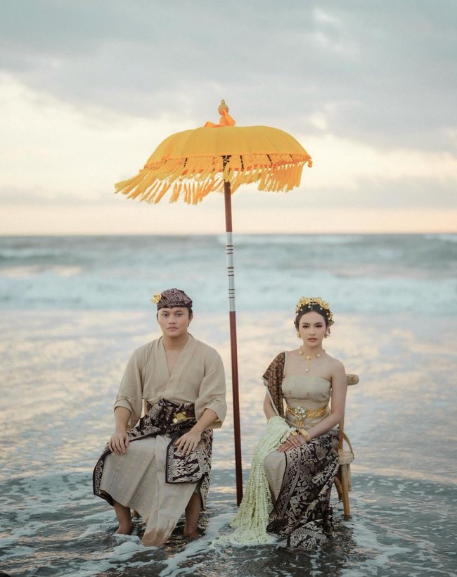 Berlatar di sebuah pantai, begini gaya keduanya kala duduk berdampingan. Foto: Instagram/@axioo
