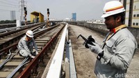 Panas terik matahari tak menyurutkan semangat petugas melakukan pemeriksaan jalur LRT Jakarta.  