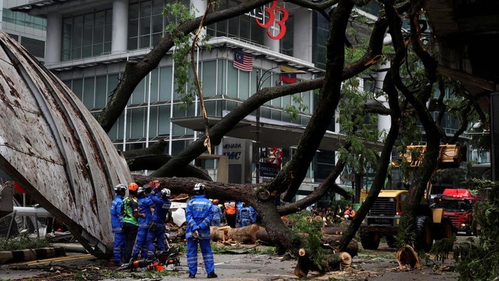 A man clicks a picture of a tree fallen across Jalan Sultan Ismail, one of Kuala Lumpur's busiest roads smashing multiple cars and disrupting monorail service, in Kuala Lumpur, Malaysia May 7, 2024. REUTERS/Hasnoor Hussain     TPX IMAGES OF THE DAY
