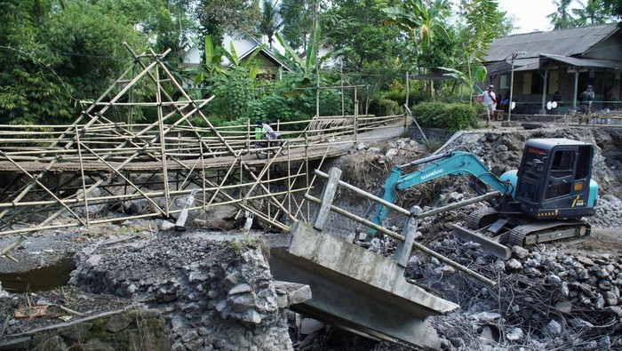 Sejumlah warga melintasi jembatan darurat dari bambu di Lumajang, Jawa Timur, Rabu (8/5/2024). Masyarakat setempat secara swadaya membuat jembatan darurat untuk bisa melintas sembari menunggu proses perbaikan jembatan Kali Durek yang putus akibat diterjang banjir lahar hujan Semeru. ANTARA FOTO/Irfan Sumanjaya/nym.