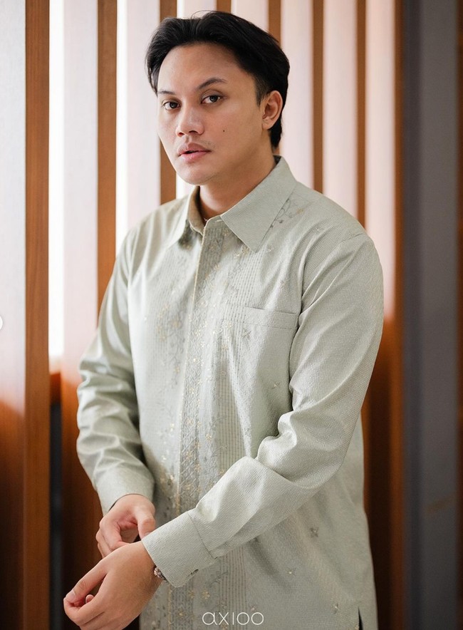 Penyanyi yang akrab disapa Iky itu tampil rapih dan gagah mengenakan kemeja berwarna sage. Kemeja tersebut tampak simpel namun elegan dengan bordiran berwarna senada di bagian tengahnya. Foto: Instagram/@rizkyfbian